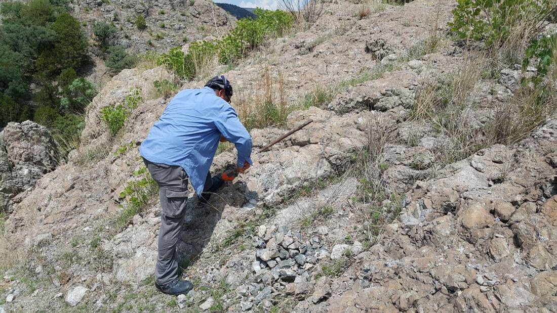 Geólogo tomando muestras en un afloramiento de perlita durante el trabajo de campo